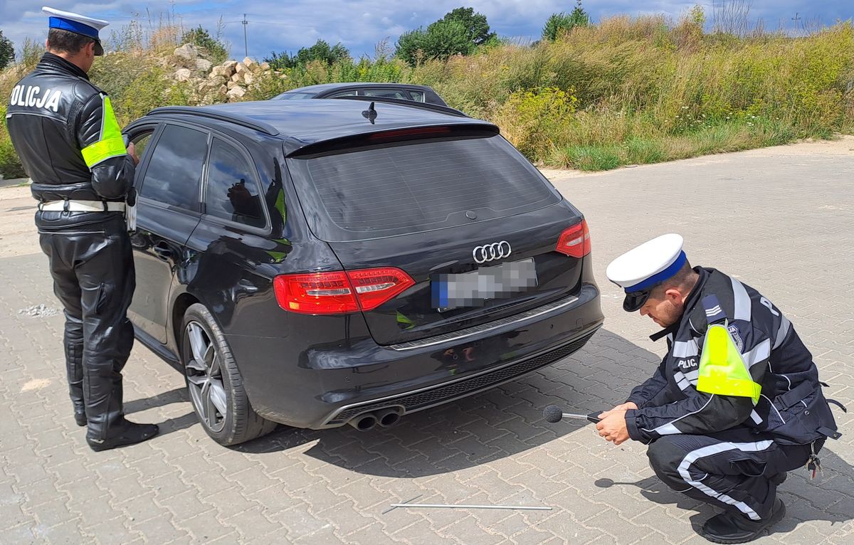 policjanci z son0ometrem przy samochodzie Audi