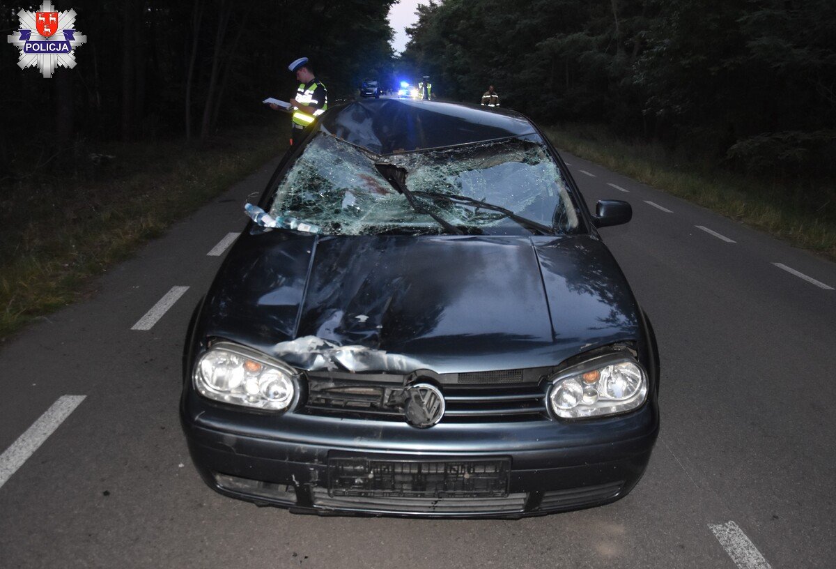 uszkodzony samochód volkswagen i policjant na drodze
