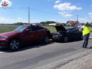 policjant fotografuje uszkodzone samochody bmw i audi