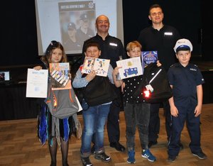 Policjanci i dzieci z nagrodami za najlepsze prace w konkursie.