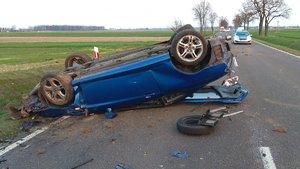 Leżący na jezdni uszkodzony samochód marki Hyundai