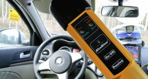 zdjęcie ilustracyjne - wnętrze samochodu, czapka policyjna i alcoblow