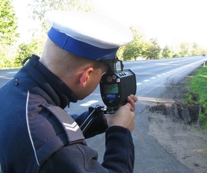 policjant z radarowym miernikiem prędkości