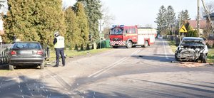 policjant i uszkodzone pojazdy na miejscu wypadku drogowego