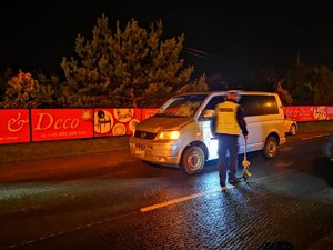 samochód marki Volkswagen Transporter i policjant na miejscu wypadku drogowego