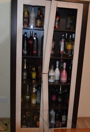 uszkodzona witryna z butelkami alkoholu