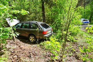 uszkodzone audi w lesie i policyjny radiowóz