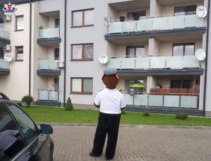 komisarz Miś przed blokiem mieszkalnym