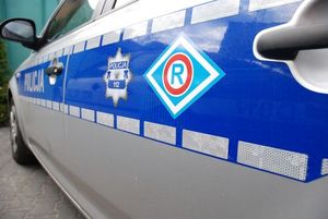 zdjęcie ilustracyjne - element oznakowanego radiowozu z napisem Policja