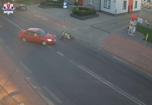 samochód marki Mitsubishi i motocykl marki Kawasaki z leżącym na jezdni motocyklistą