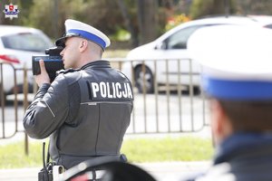 policjant Wydziału Ruchu Drogowego używający radarowego miernika prędkości