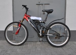 stojący przy ścianie budynku czerwono-czarny rower marki Rayon Rapido