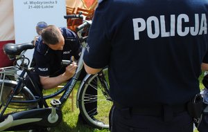 policjant nanosi urządzeniem numer na ramę roweru