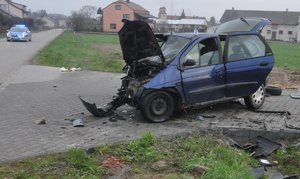 stojący na drodze uszkodzony samochód marki Renault, w tle radiowóz