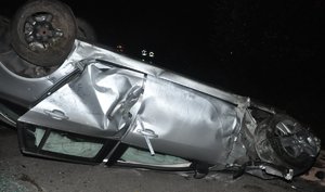 leżący na dachu uszkodzony samochód marki Opel Insignia