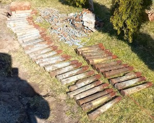 leżące na trawiastym podłożu pociski przeciwpancerne i amunicja do karabinu