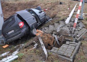 uszkodzony samochód marki Chrysler, uszkodzone elemnty infrastruktury drogowo-kolejowej