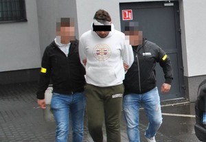 policjanci kryminalni prowadzą zatrzymanego