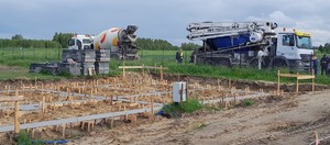 plac budowy, w tle samochody ciężarowe ze sprzętem