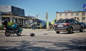 miejsce wypadku drogowego, uszkodzony motocykl marki Yamaha, stojący na drodze samochód marki Suzuki