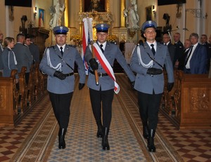 policjanci pocztu sztandarowego idą w kościele