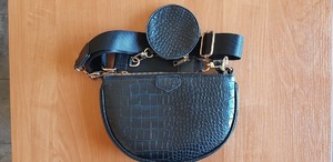 leżąca na blacie torebka z ciemnego tworzywa