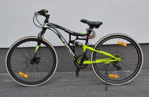 stojący w pobliżu ściany zielono-czarny rower