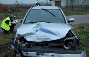 policjanci przy uszkodzonym samochodzie Opel