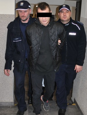 policjanci prowadzą korytarzem podejrzanego