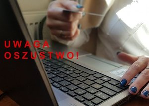dłonie na klawiaturze i napis Uwaga oszustwo