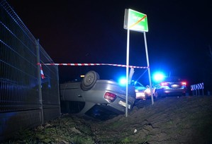 miejsce zdarzenia drogowego, leżący w rowie na dachu samochód marki Honda