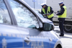 policyjny radiowóz, w tle policjanci