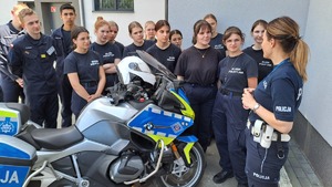 uczniowie i policjantka przy motocyklu policyjnym