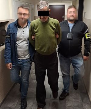 zatrzymany mężczyzna prowadzony przez mężczyzn