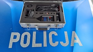 sonometr w walizce na pokrywie silnika pojazdu z napisem Policja