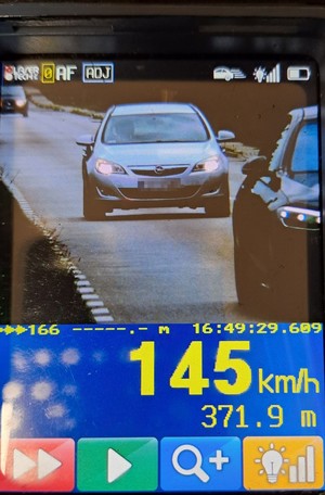 ekran miernika prędkości z zarejestrowanym obrazem - samochód Opel i wskazanie prędkości 145 km na godz.