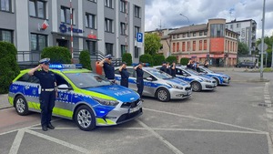 radiowozy i salutujący policjanci