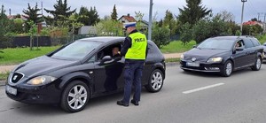 samochody i policjant drogówki z urządzeniem do badania stanu trzeźwości