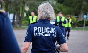policjanci, kobieta w granatowej koszulce z napisem Policja przewodnik psa