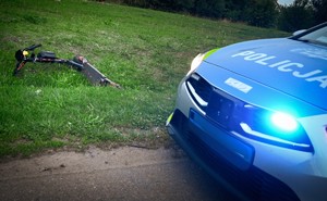 leżąca na trawiastym podłożu hulajnoga, obok radiowóz