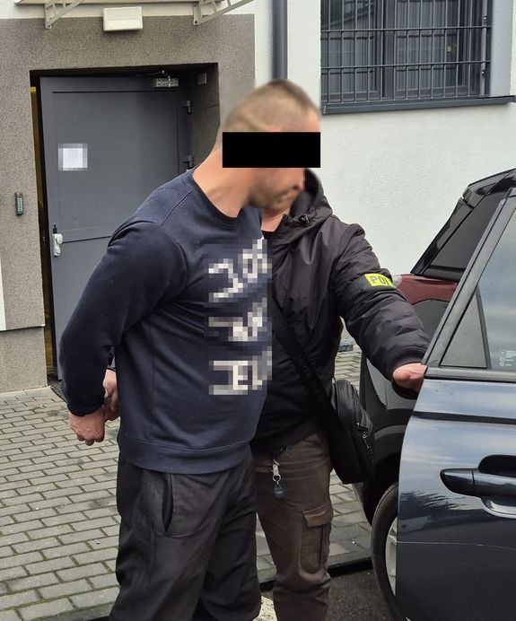 podejrzany o kierowanie gróźb prowadzony do samochodu przez nieumundurowanego policjanta