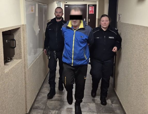 umundurowani policjanci prowadzą podejrzanego