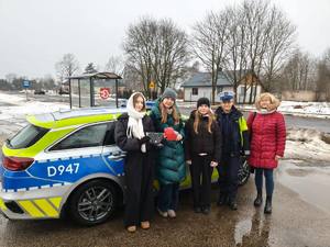 dziewczynki z opiekunką i policjantką przy radiowozie