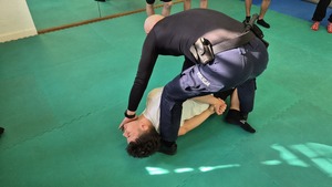 policjant i uczeń leżący na macie