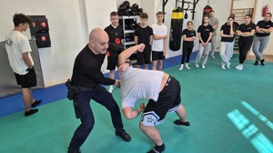 policjant i uczeń upadający na matę