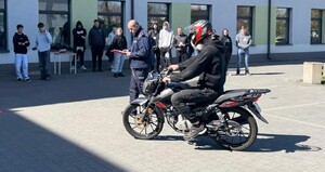 uczestnik turnieju na motocyklu w tle policjant i budynki