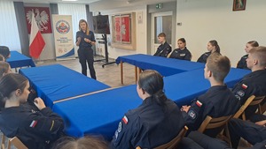 uczniowie i policjantka w sali odpraw