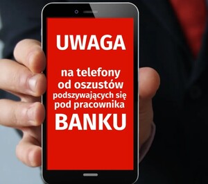 dłoń ze smartfonem, napisy na ekranie smartfona uwaga na oszustów podszywających się pod pracowników banku