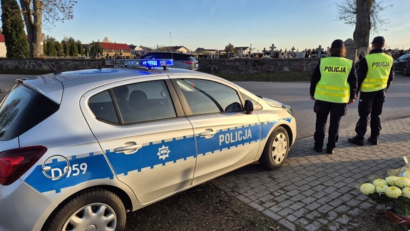 radiowóz i policjanci w tle cmentarz