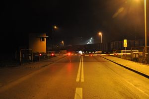 opuszczone szlabany, na torach stoją wagony towarowe